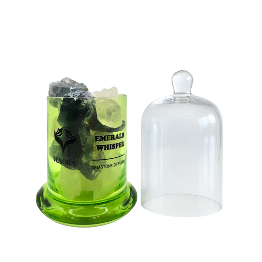 Emerald Whisper Gemstone Diffuser by Venora with genuine emerald crystals inside a clear glass vessel on a white background.