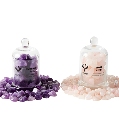 Amethyst and Rose Aura gemstone diffusers surrounded by polished amethyst and rose aura crystals arranged elegantly on a clean background.