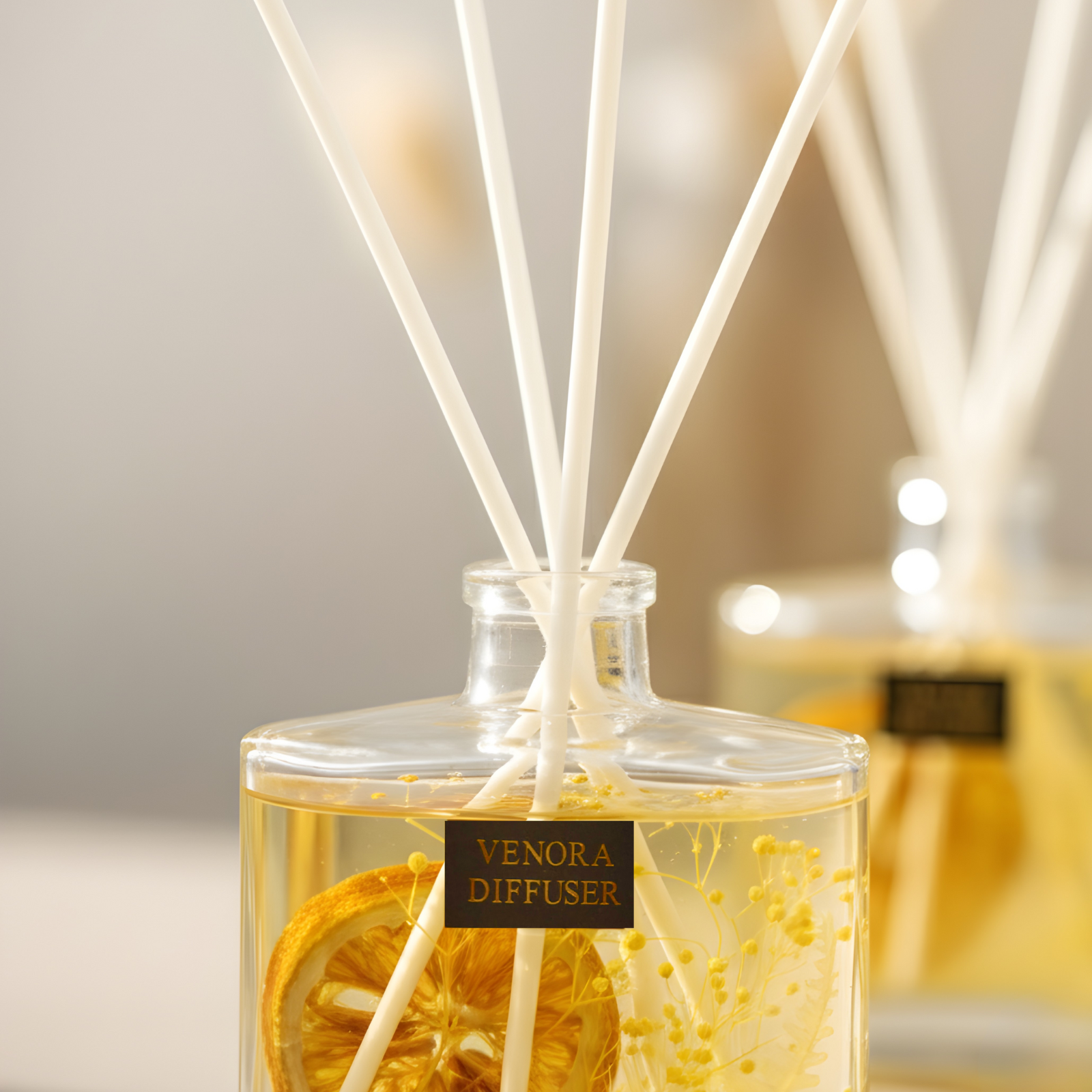 Cinematic close-up of Venora’s Citrus Glow reed diffuser highlighting the reeds, botanicals, and dried orange slice with warm, elegant lighting.