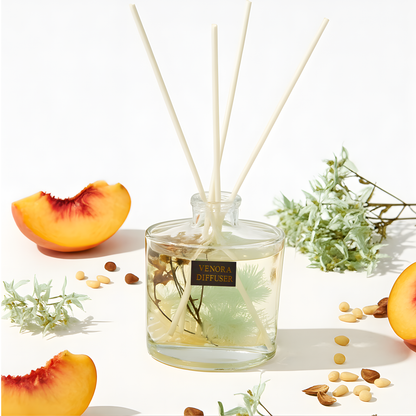 Minimalist composition of Venora Golden Peach diffuser with peach, pine, white tea, and botanical elements arranged in a luxury fragrance layout.