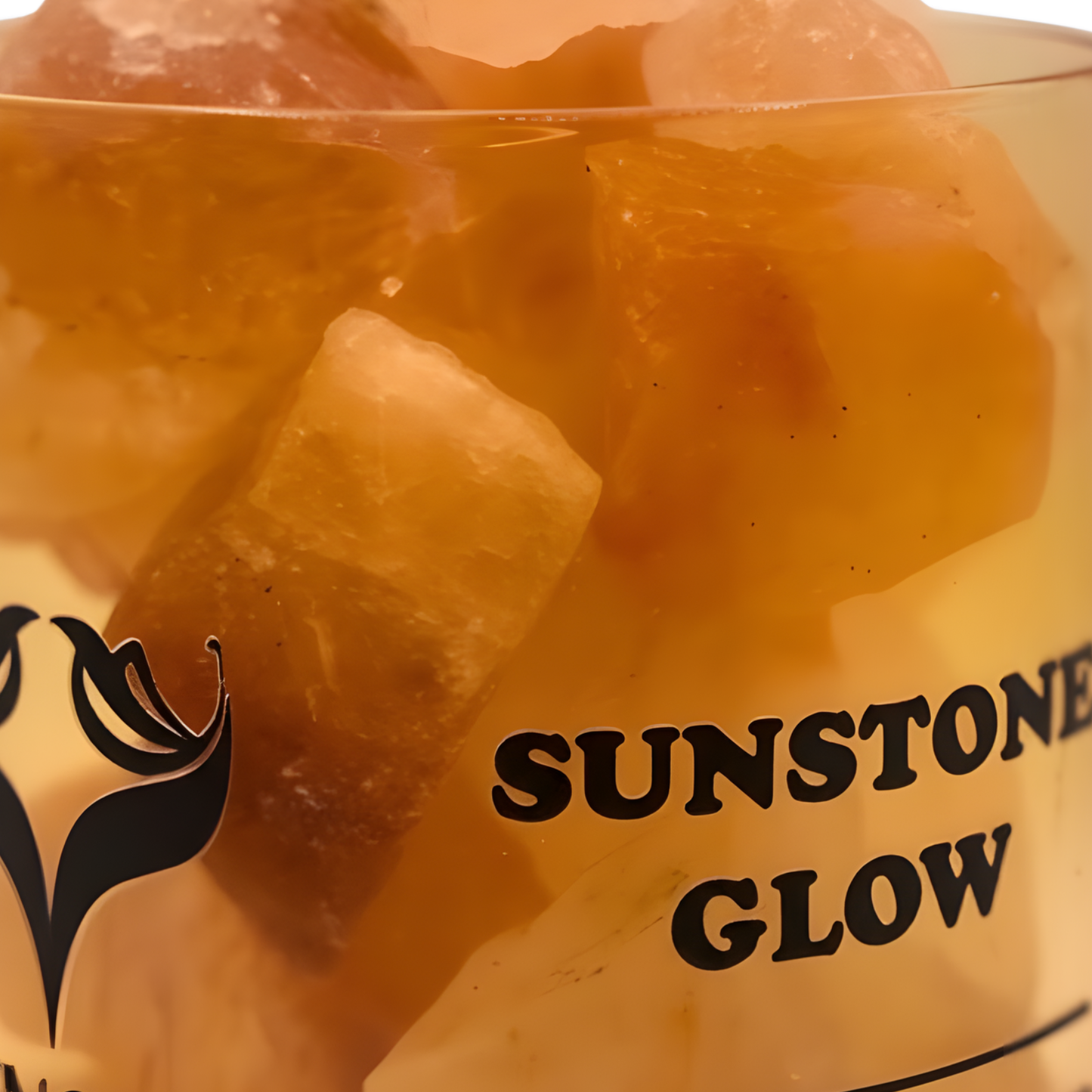 Close-up of sunstone crystals inside the Sunstone Glow diffuser with warm orange reflections and elegant lighting.