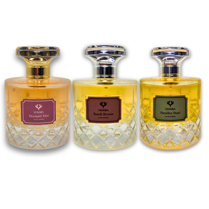 Three perfumes styled together with contrasting tones: feminine warm lighting for Mermaid Mist, dark moody lighting for Paradise Pearl, and cool fresh tones for Bondi Breeze. Cinematic fragrance photography.